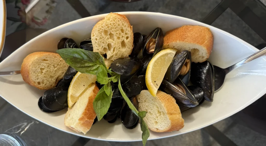 Čerstvé slávky (cozze) s citrónom a opečenou bagetou podávané v Bistrote na ostrove La Maddalena.